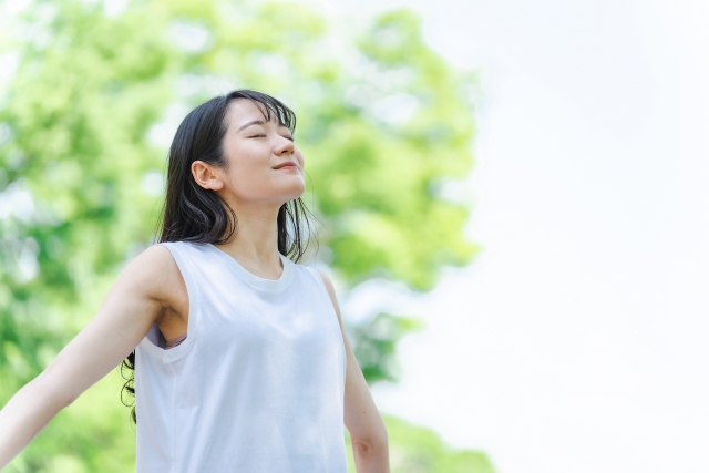 山梨昭和町のヨガスタジオで、50代の女性が心と身体を整えるために深い呼吸でリラックスしている風景